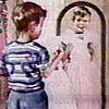 Boy holding up a dress in front of a mirror 